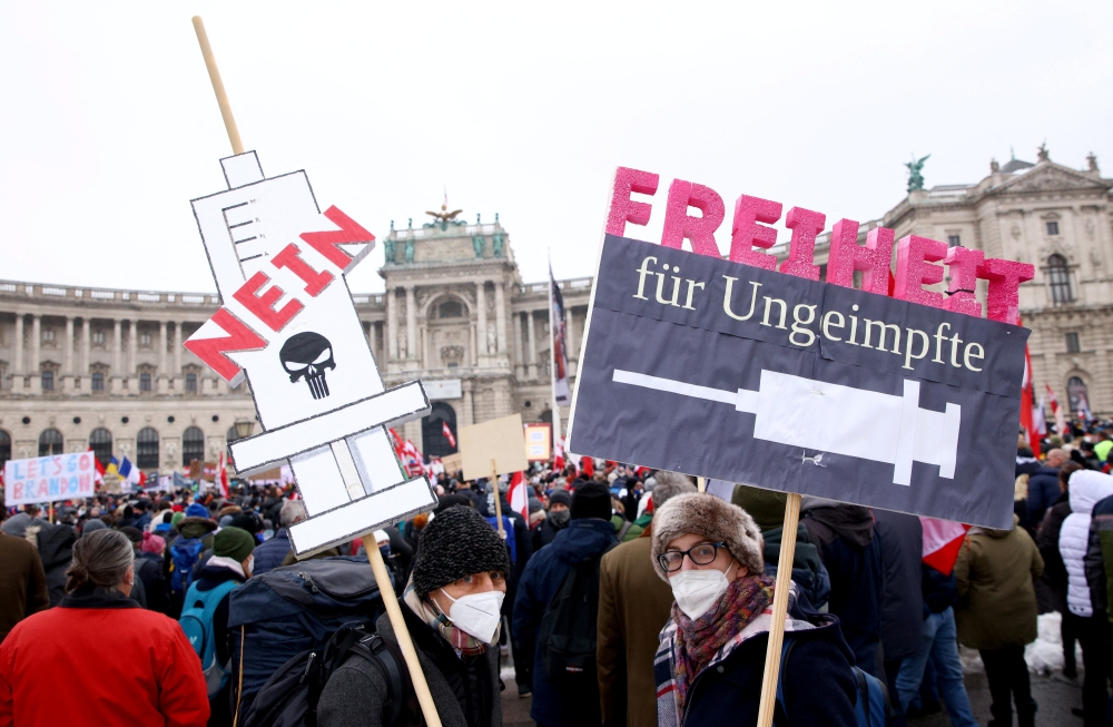 Demonstrators hold flags and placards as they gather to protest against the coronavirus disease (COVID-19) restrictions and the vaccine mandate in front of Hofburg Palace in Vienna, Austria, December 11, 2021. REUTERS.
