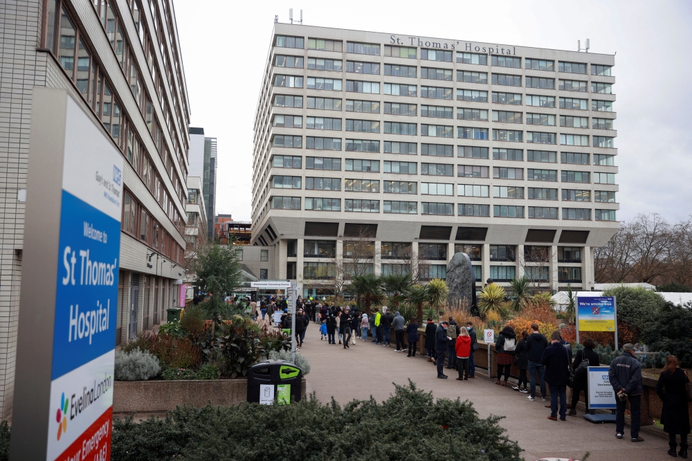 People queue outside a coronavirus disease (COVID-19) vaccination centre at St Thomas's Hospital in London, Britain, December 13, 2021. Reuters/Hannah McKay