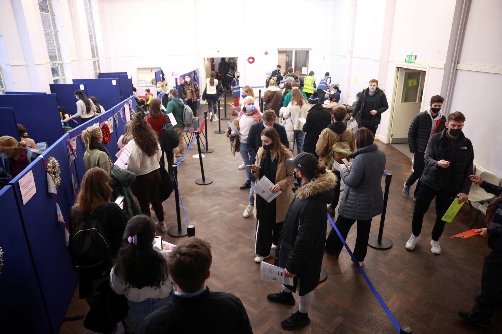 People queue at a coronavirus disease (COVID-19) vaccination centre in London, Britain, December 15, 2021. REUTERS/Hannah McKay