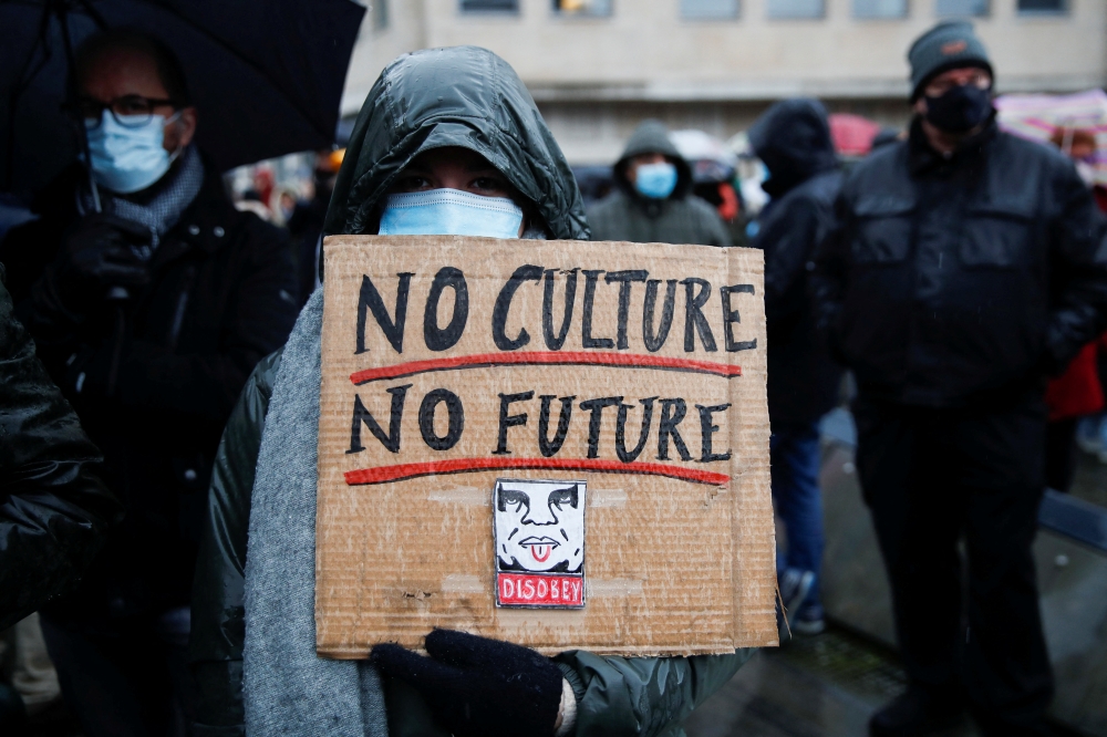 A woman holds a banner reading 