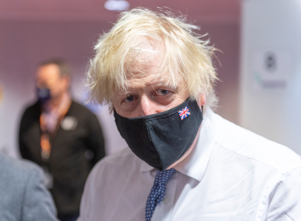 British Prime Minister Boris Johnson visits COVID-19 vaccination centre, amidst the spread of the coronavirus disease (COVID-19) pandemic, at the Rainbow Pharmacy in the Open University Campus, Walton Hall, Milton Keynes, Britain, December 29, 2021. Geoff Pugh/Pool via REUTERS