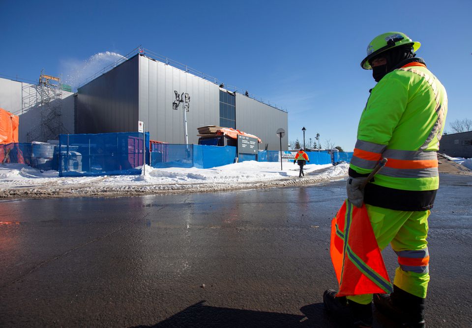 A worker monitors traffic around a new extension of the National Research Council of Canada building under construction, in Montreal, Quebec, Canada February 4, 2021. REUTERS/Christinne Muschi

