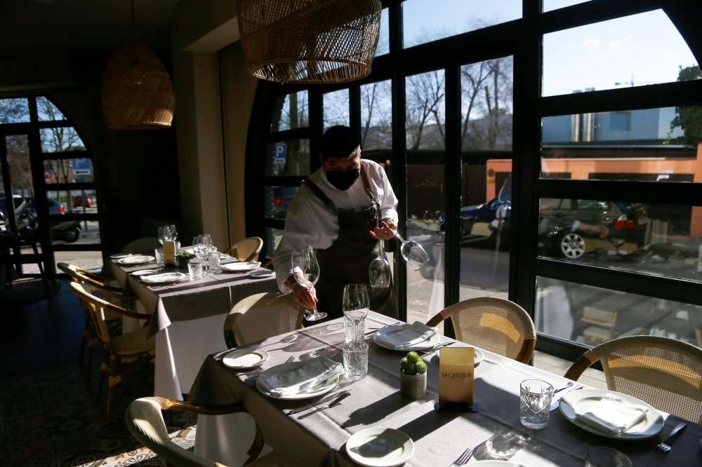 A waiter sets a table at La Querida restaurant in Pozuelo de Alarcon, Madrid, Spain December 28, 2021. Picture taken December 28, 2021. REUTERS/Javier Barbancho
