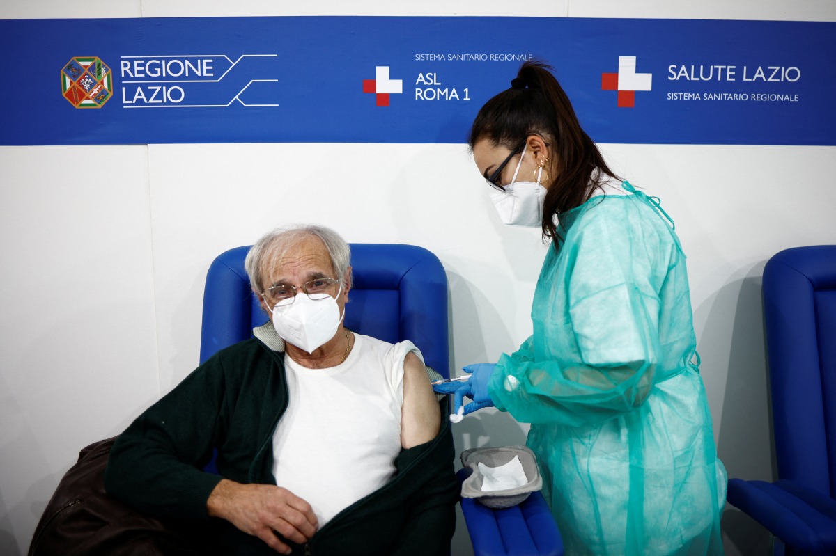 A man receives a dose of the Moderna vaccine against the coronavirus disease (COVID-19), on the day the government is expected to approve new rules for schools and COVID-19 vaccination for workers, at the Music Auditorium in Rome, Italy, January 5, 2022. REUTERS/Guglielmo Mangiapane
