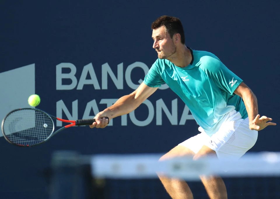 Bernard Tomic from Australia hits a shot against Roberto Bautista Agut from Spain (not pictured) during the Rogers Cup tennis tournament at Stade IGA. Mandatory Credit: Jean-Yves Ahern-USA TODAY Sports

