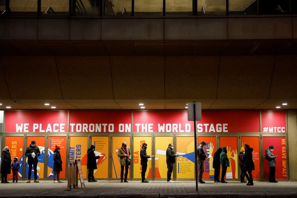 People queue up for their COVID-19 vaccine booster shots at a clinic inside the Metro Toronto Convention Centre, as the latest Omicron variant emerges as a threat, in Toronto, Ontario, Canada December 22, 2021. REUTERS/Cole Burston


