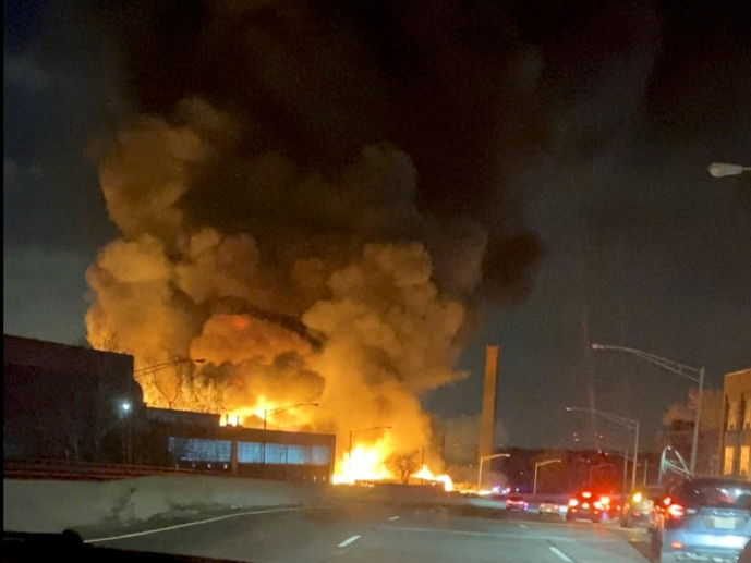A thick plume of smoke rises over a burning building which is seen through the windshield of a vehicle, in Passaic, New Jersey, U.S., January 14, 2022 in this screen grab obtained from a video on social media. Maria Alberto/via REUTERS 
