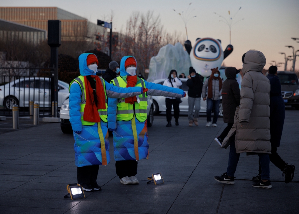 Volunteers show the way to an Olympic parking lot outside the closed loop 