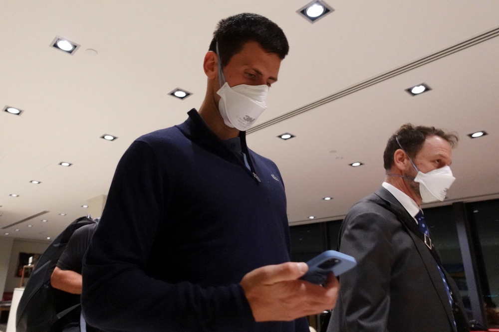 Serbian tennis player Novak Djokovic walks in Melbourne Airport before boarding a flight, after the Federal Court upheld a government decision to cancel his visa to play in the Australian Open, in Melbourne, Australia, January 16, 2022. REUTERS/Loren Elliott