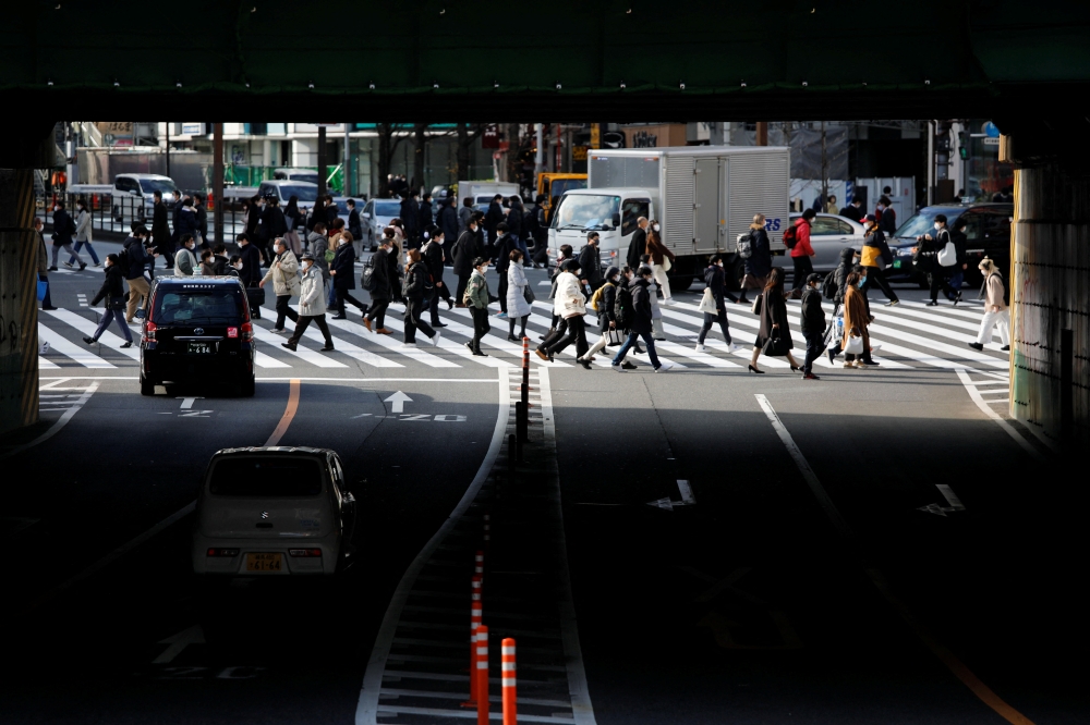 People wearing protective face masks walk on a pedestrian crossing, amid the coronavirus disease (COVID-19) pandemic, in Tokyo, Japan January 19, 2022. REUTERS/Issei Kato