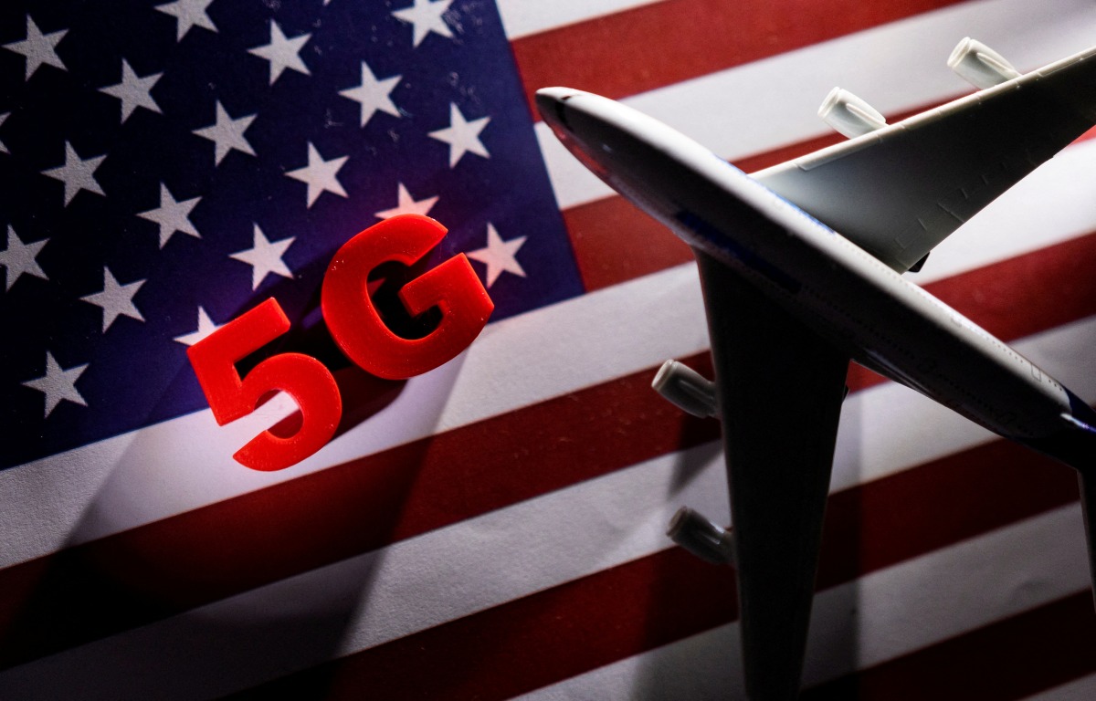 FILE PHOTO: 5G words and an airplane toy are placed on a printed U.S. flag in this illustration taken January 18, 2022. REUTERS/Dado Ruvic/Illustration/File Photo
