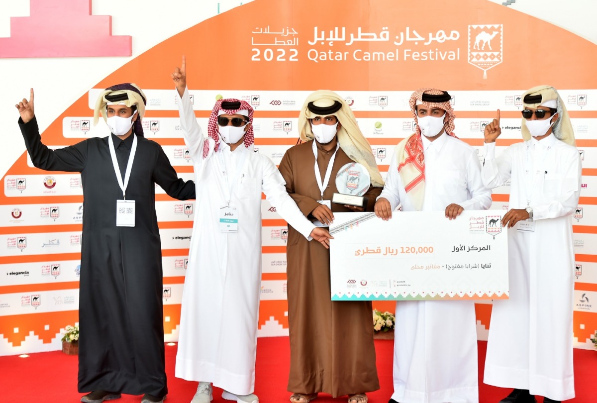 A winner of camel racing contest being given a cheque.

