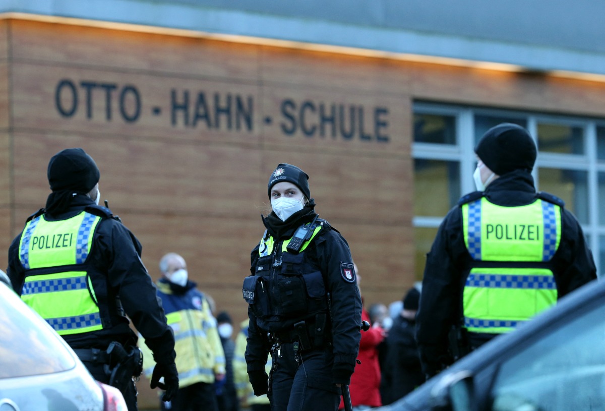 Police walks in front of a school in Hamburg Jenfeld, Germany, February 1, 2022, during a major police operation after an armed youth is believed to have entered the building earlier today. REUTERS/Cathrin Mueller
