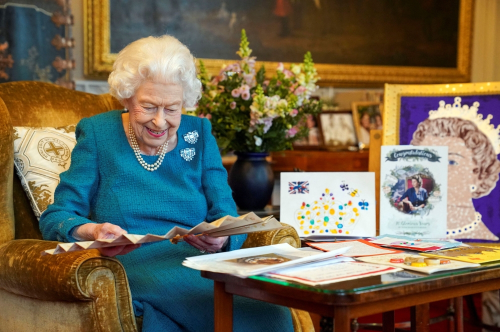 Britain's Queen Elizabeth looks at a fan as she views a display of memorabilia from her Golden and Platinum Jubilees in the Oak Room at Windsor Castle, Windsor, Britain, in this undated picture issued on February 4, 2022. Steve Parsons/Pool via REUTERS