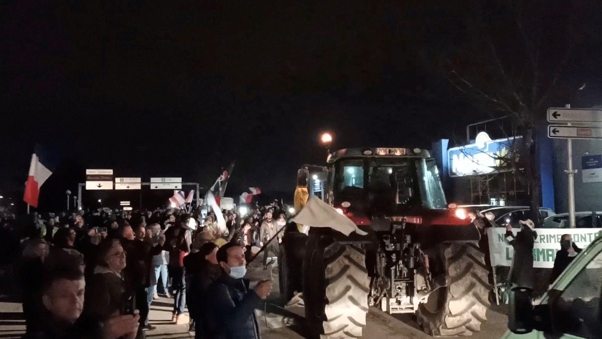 Supporters wave flags and cheer as truck and car drivers, part of a 'Freedom Convoy' on its way to Paris, arrive in Lyon, France February 10, 2022 in this still image taken from a video obtained from a social media. Video taken February 10, 2022. Gabriel Bonnaveira/via REUTERS 