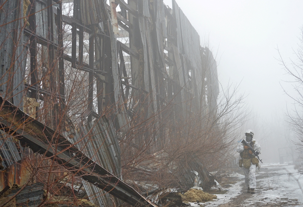 A service member of the Ukrainian armed forces walks at combat positions near the line of separation from Russian-backed rebels outside the town of Avdiivka in the Donetsk Region, Ukraine February 11, 2022. Reuters/Oleksandr Klymenko 