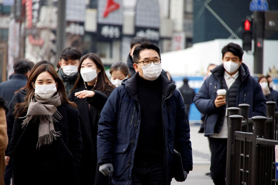 People wearing masks to prevent contracting the coronavirus disease (COVID-19) walk on a street in downtown Seoul, South Korea, January 5, 2022. REUTERS/Heo Ran