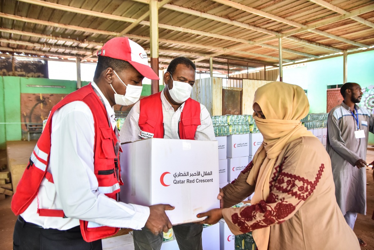A beneficiary receiving food parcel provided by QRCS to flood affected people in Sudan.