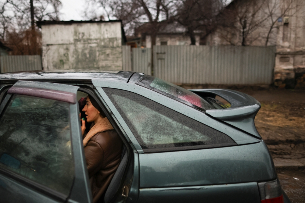 A local resident sits in a car as they packing to leave the city, after Russian President Vladimir Putin authorized a military operation in eastern Ukraine, in Mariupol, February 24, 2022. REUTERS/Carlos Barria
