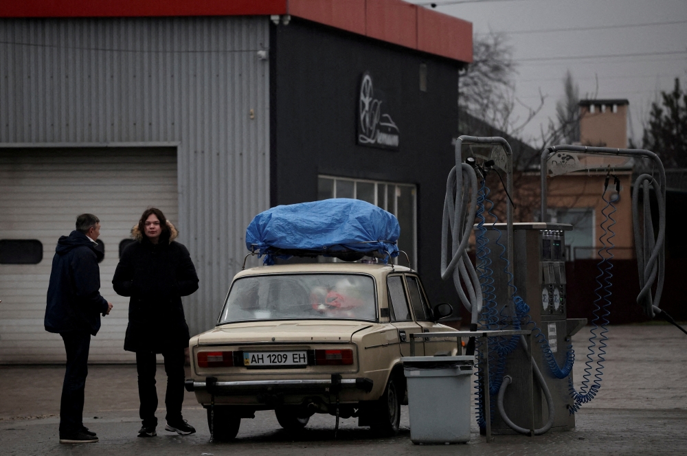 Local residents are seen refueling at gas station after Russian President Vladimir Putin authorized a military operation in eastern Ukraine, in Mariupol, February 24, 2022. REUTERS/Carlos Barria/File Photo