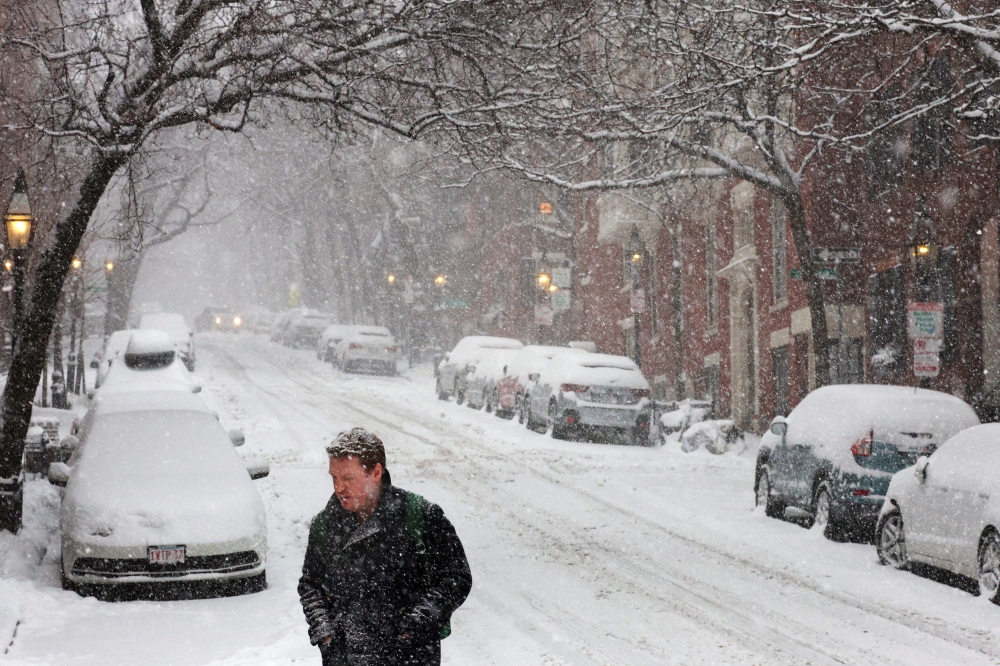 A pedestrian walks through falling snow during a winter storm in Boston, Massachusetts, U.S., February 25, 2022. REUTERS/Brian Snyder