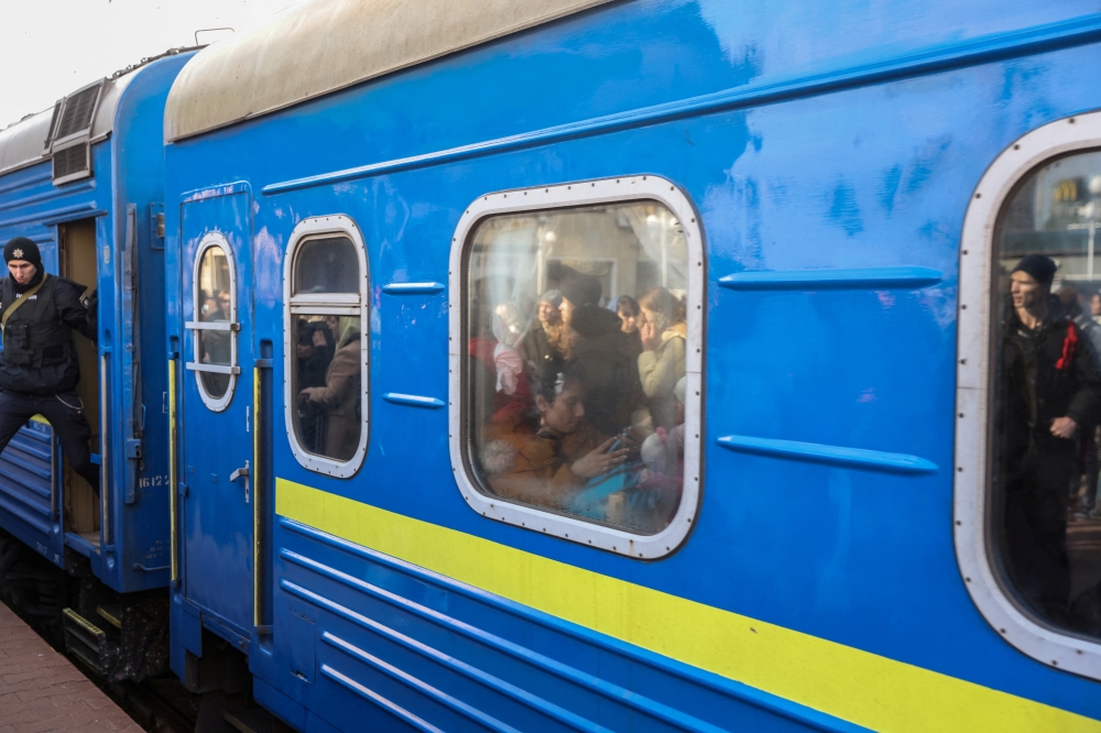 People waiting for an second train to board, reflect on a leaving a evacuation train from Kyiv to Lviv at Kyiv central train station, Ukraine, February 25, 2022. REUTERS/Umit Bektas