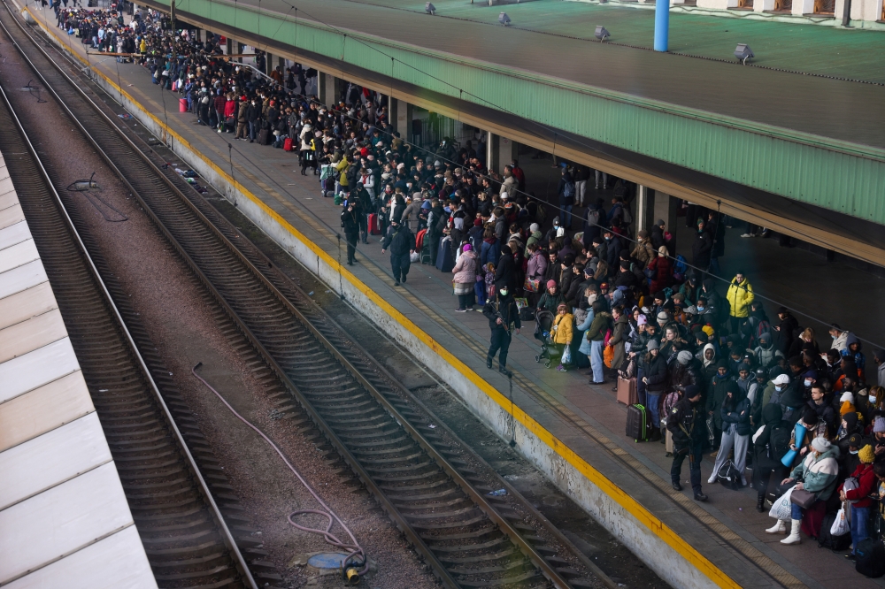 People wait to board an evacuation train from Kyiv to Lviv at Kyiv central train station, Ukraine, February 25, 2022. Picture taken through a window REUTERS/Umit Bektas