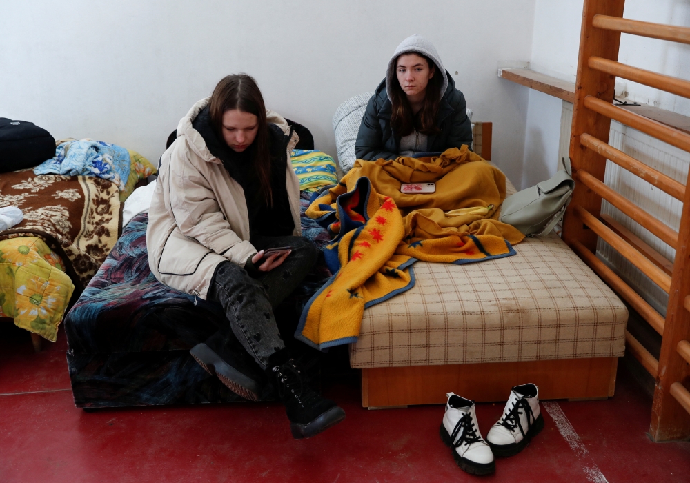 Women look on at a refugee shelter after fleeing Russia's invasion of Ukraine, in Beregsurany, Hungary, February 28, 2022. REUTERS/Bernadett Szabo