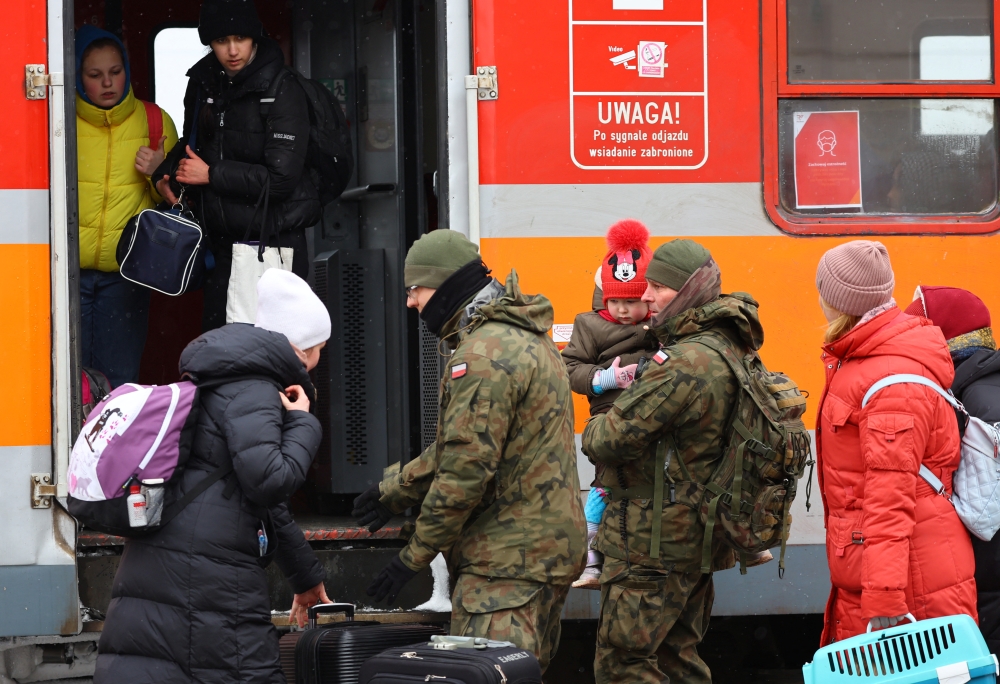 Polish army soldiers assist people to board a train to Krakow after crossing the border from Ukraine to Poland, after fleeing the Russian invasion of Ukraine, at the border checkpoint in Medyka, Poland, March 9, 2022. REUTERS/Fabrizio Bensch
