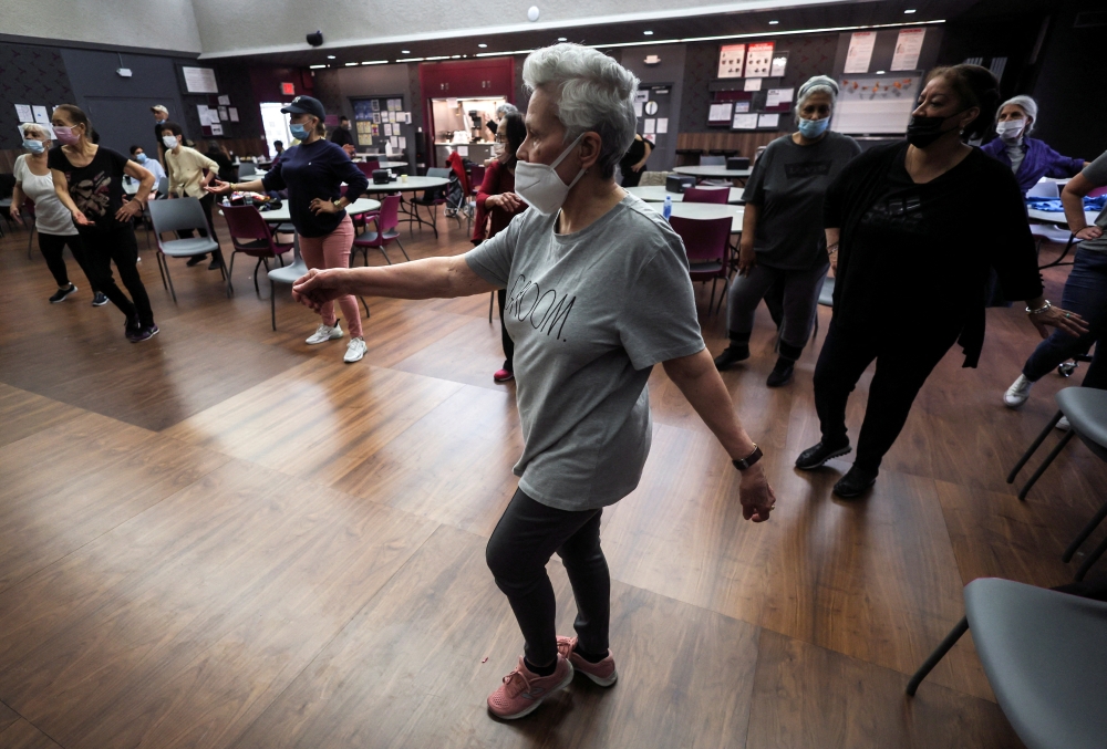 Seniors dance together during Walter Perez's dance class at the YM & YWHA of Washington Heights and Inwood, where he gives an audience of older adults an opportunity to socialize, stay fit and enjoy the music from their past, during the coronavirus (COVID-19) pandemic in New York City, New York, U.S. March 7, 2022. REUTERS/Mike Segar