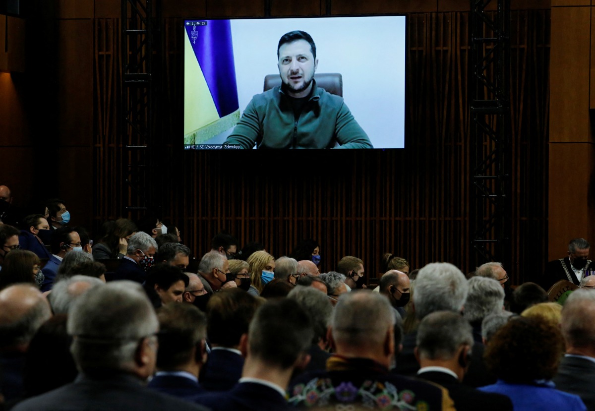 Members of the House of Commons and Senate listen as Ukraine's President Volodymyr Zelenskiy, who appears on a screen, addresses Canada's parliament in Ottawa, Ontario, Canada March 15, 2022. REUTERS/Patrick Doyle
