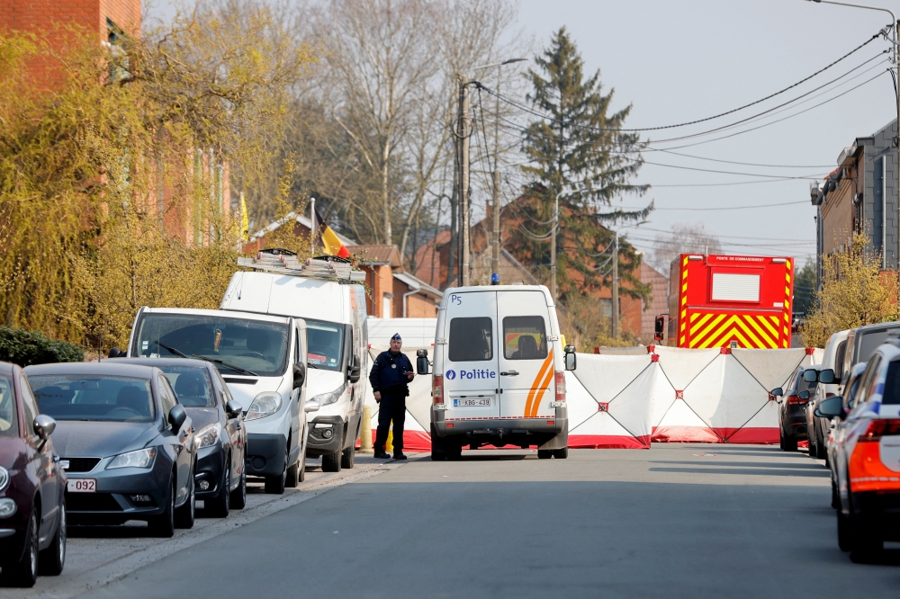 A police officer looks on at the site where a vehicle drove into a group of Belgian carnival performers who were preparing for a parade in the village of Strepy-Bracquegnies, Belgium March 20, 2022. REUTERS/Johanna Geron