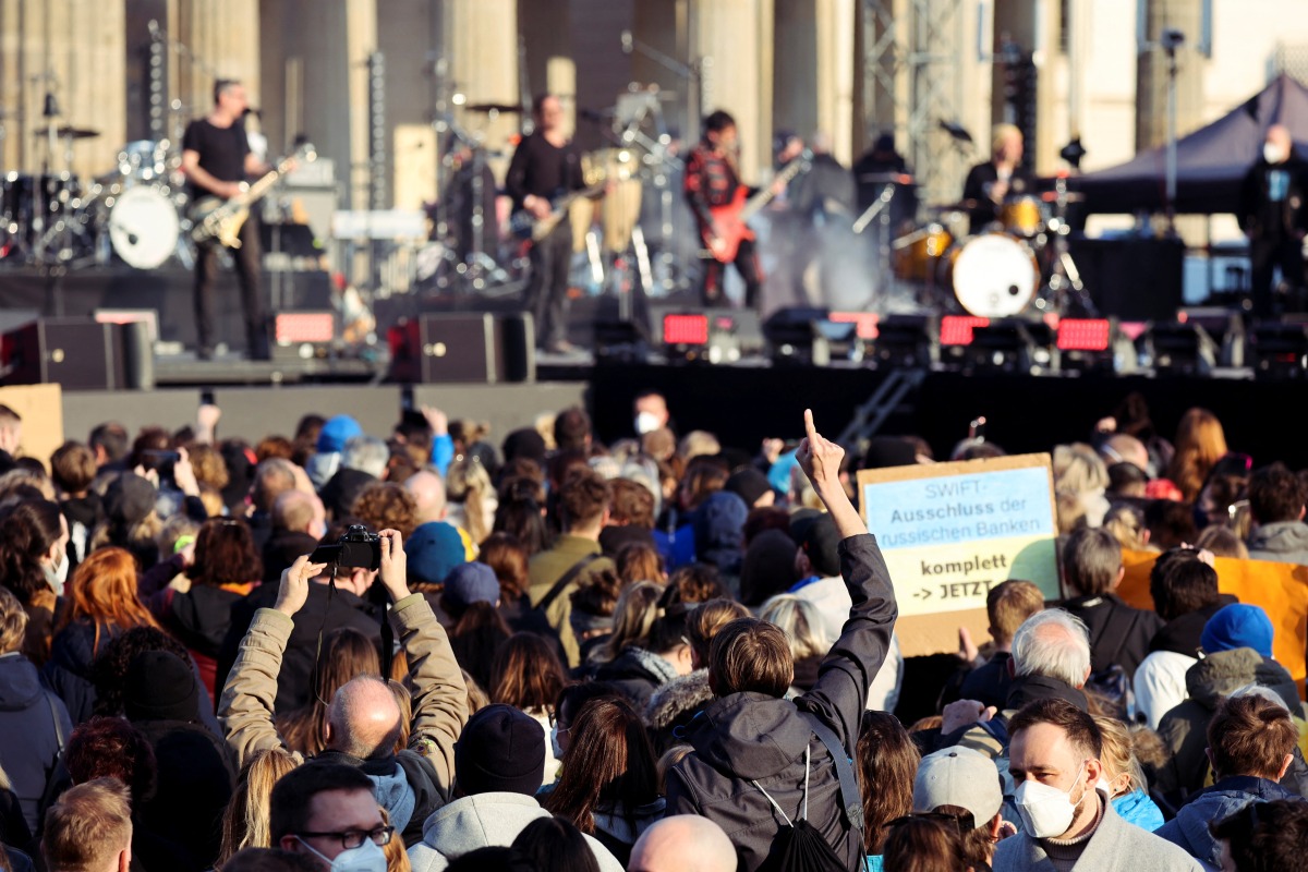 A person holds a sign depicting the Ukrainian national flag during the anti-war concert 