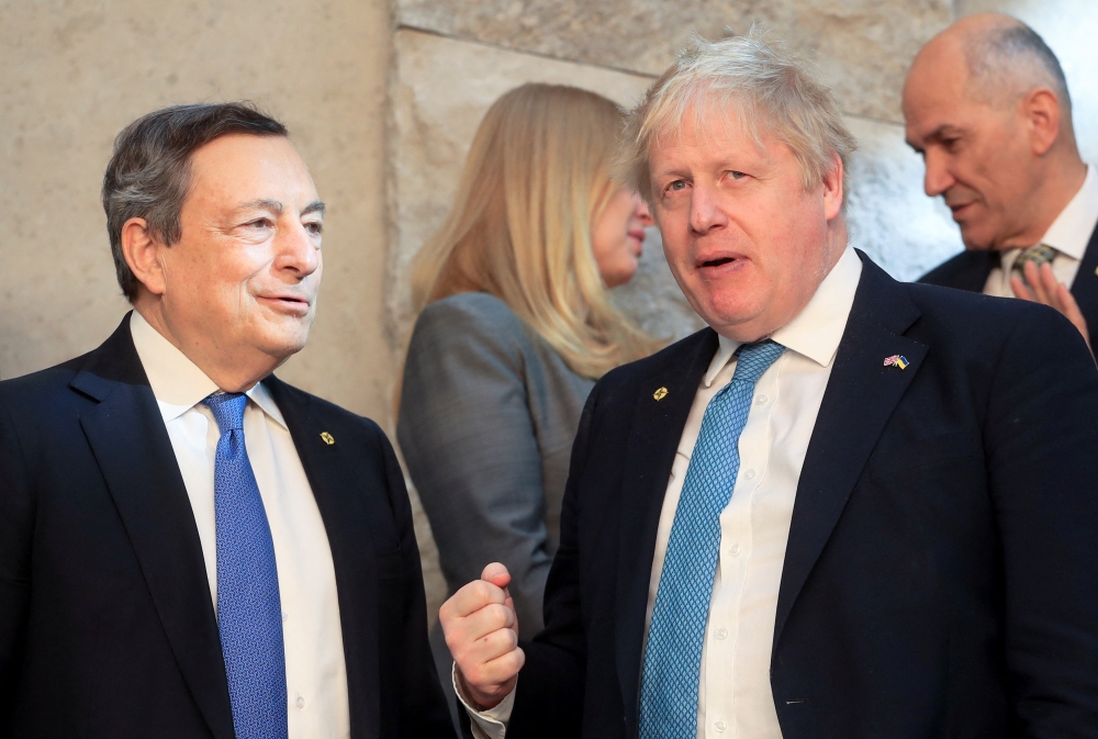 Italy's Prime Minister Mario Draghi stands next to British Prime Minister Boris Johnson before a NATO summit to discuss Russia's invasion of Ukraine at the alliance's headquarters in Brussels, Belgium, March 24, 2022. REUTERS.