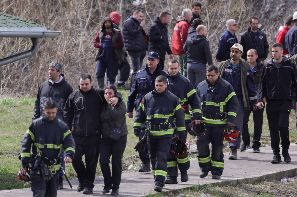 Rescue miners walk by family members of miners outside a coal mine, after a shaft collapsed killing at least eight miners, according to RTS state television, in Sokobanja, southern Serbia, April 1, 2022. REUTERS/Antonio Bronic