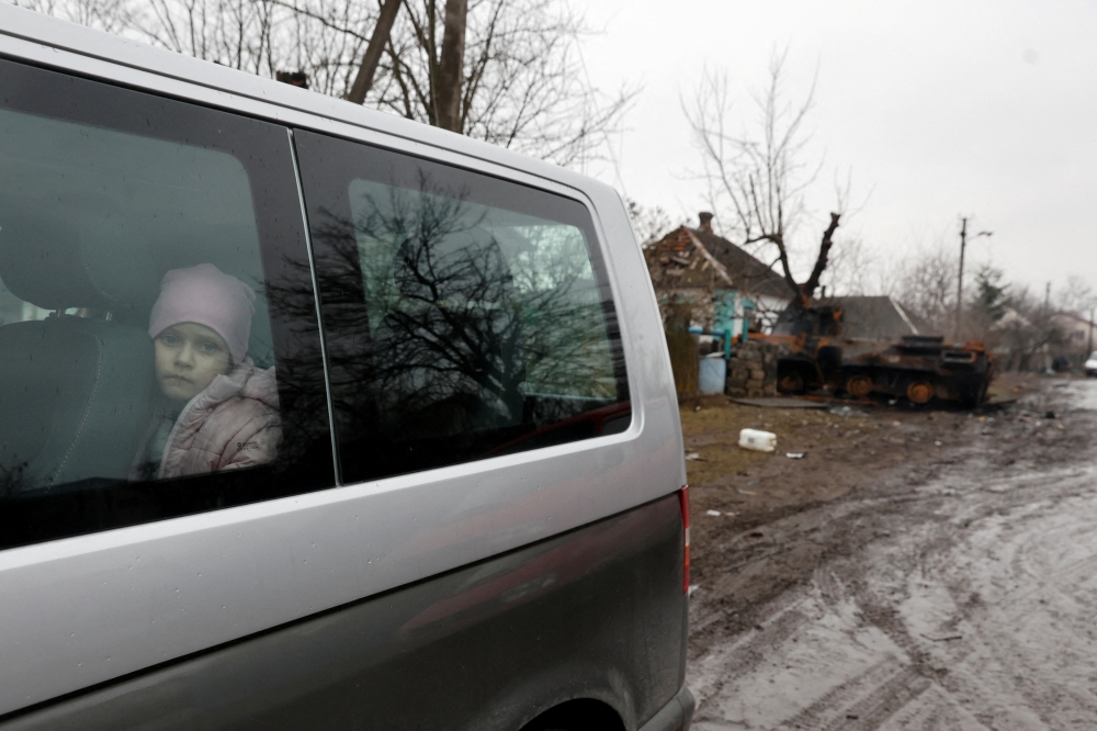 A girl looks out through a window of a van, as Russia's attack on Ukraine continues, in the village of Nova Basan, in Chernihiv region, Ukraine April 1, 2022. Picture taken April 1, 2022. REUTERS/Serhii Nuzhnenko TPX