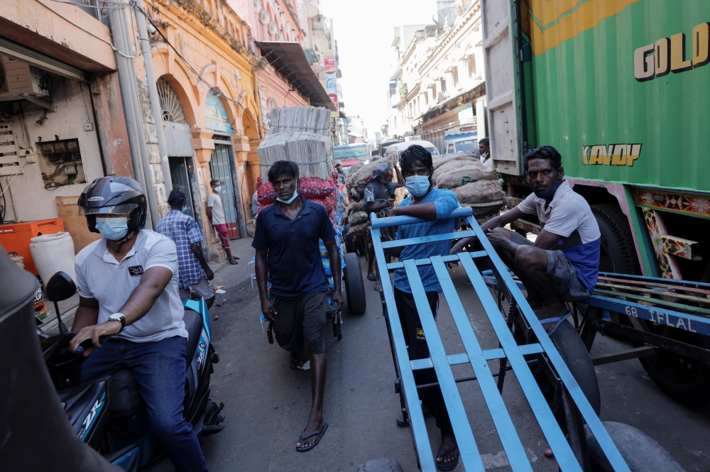 Men wait with their carts at a market, amid the country's economic crisis in Colombo, Sri Lanka, April 7, 2022. REUTERS/Dinuka Liyanawatte