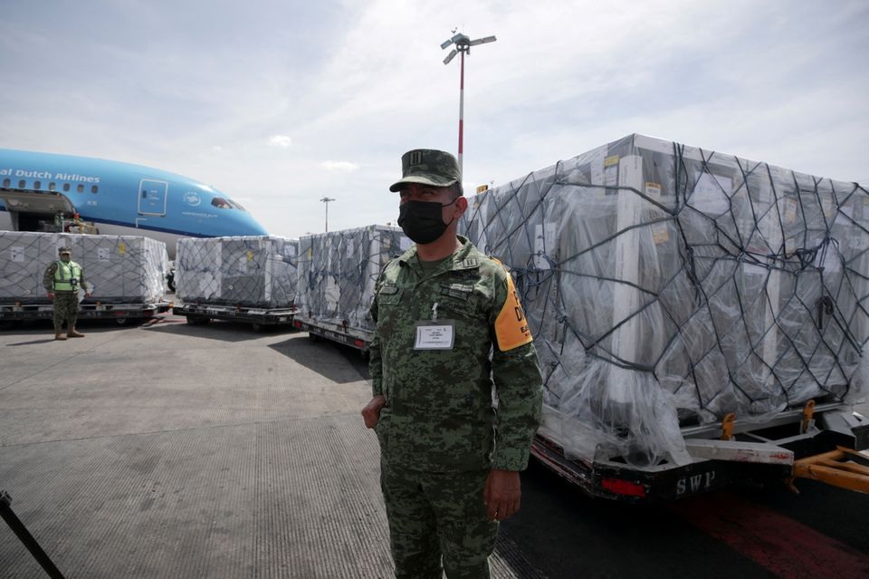 A member of the National Guard looks on as a batch of AstraZeneca coronavirus disease (COVID-19) vaccines, delivered under the COVAX scheme, is unloaded from a KLM Boeing 787 at Benito Juarez International Airport in Mexico City, Mexico May 27, 2021. REUTERS/Henny Romero/File Photo