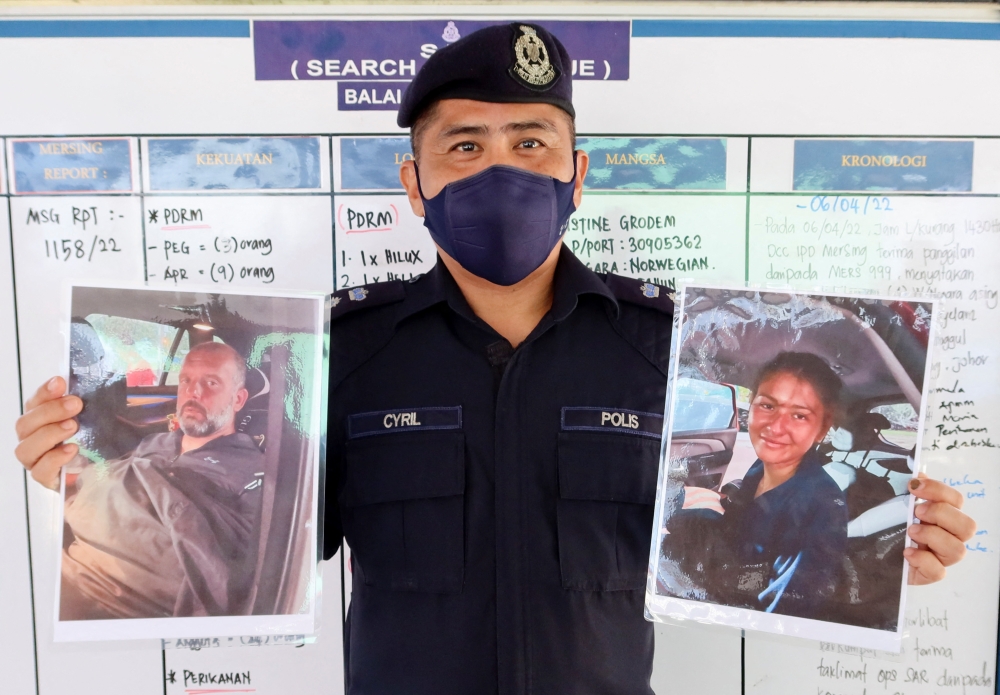 Mersing district police chief Cyril Edward shows the pictures of British man Adrian Peter Chesters and French woman Alexia Alexandra Molina, who were found safe after drifting at sea for two and a half days, during a news conference at Mersing, Johor, Malaysia, April 9, 2022. Reuters/Ebrahim Harris