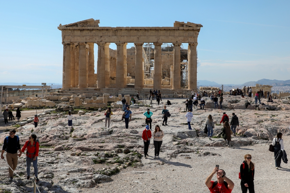 People visit the ancient Parthenon Temple atop the Acropolis hill archaeological site in Athens, Greece, February 26, 2022. REUTERS/Louiza Vradi/File Photo
