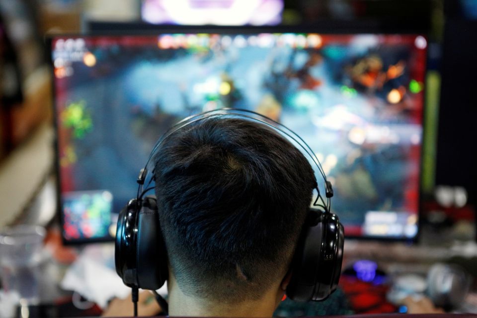 A man plays online game on a computer at an internet cafe in Beijing, China August 31, 2021. REUTERS/Florence Lo

