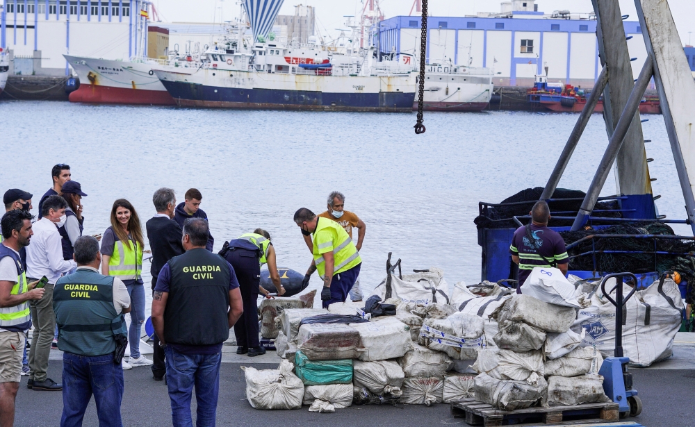 Police officers discharge drugs from the fishing boat 