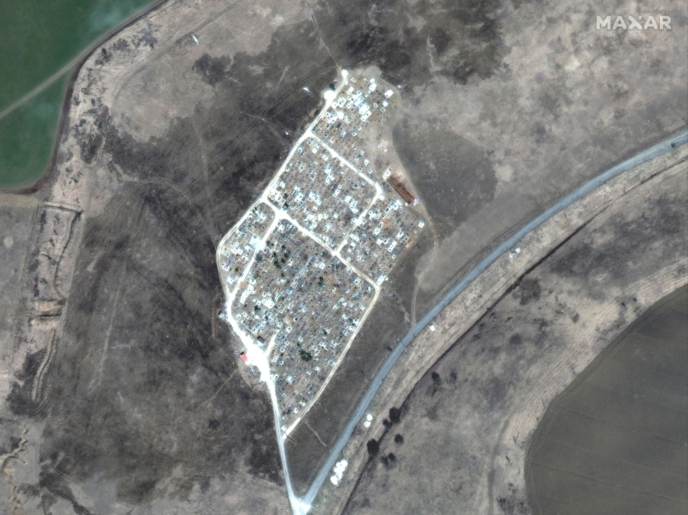 A satellite image shows the expansion of new graves at a cemetery in Vynohradne, near Mariupol, Ukraine, March 29, 2022. Satellite image 2022 Maxar Technologies/Handout via Reuters