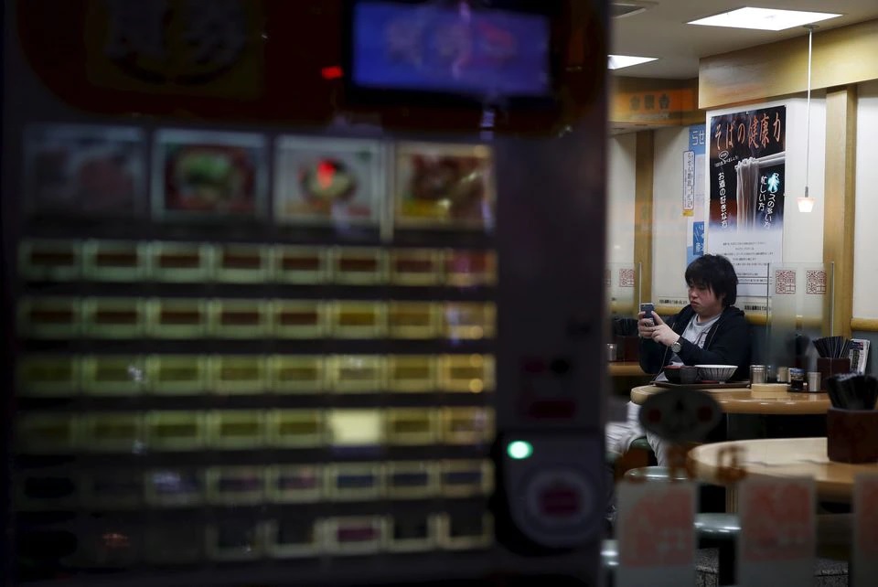 A customer looks at his mobile phone at Soba noodle restaurant at a shopping district in Tokyo, Japan, February 25, 2016. REUTERS/Yuya Shino/Files


