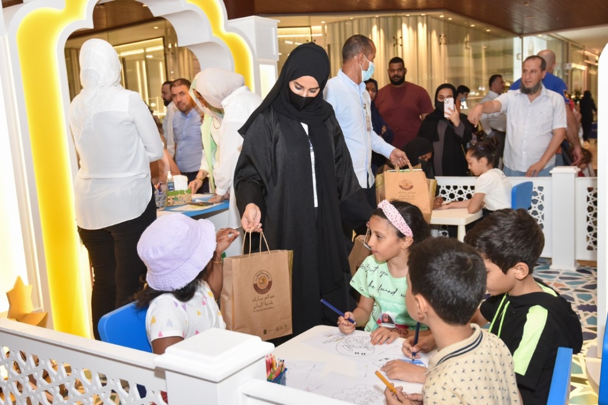 A representative of Al Rayyan Municipality distributing Eid gifts among children. 