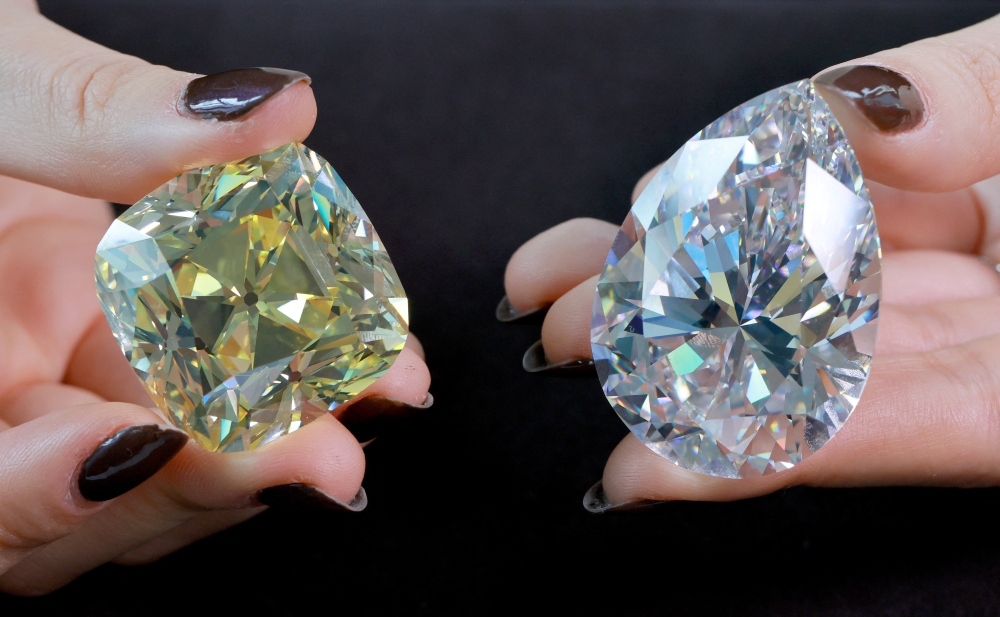 Returning for the third time since its mining in 1901, the 'Red Cross', a fancy intense yellow, cushion-shaped 205.07 carat diamond and a 228.31 carat white diamond called 'The Rock' that could fetch 30 million US dollars and is the largest ever seen throughout auction market history, are pictured during a preview at Christie's before their auction sale in Geneva, Switzerland, May 6, 2022. REUTERS/Denis Balibouse