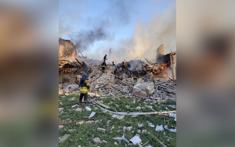 Emergency crew tend to a fire near a burning debris, after a school building was hit as a result of shelling, in the village of Bilohorivka, Luhansk, Ukraine, May 8, 2022. State Emergency Services/Handout via REUTERS