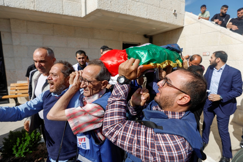 Mourners, including journalists, carry the body of Al Jazeera reporter Shireen Abu Akleh May 11, 2022. Reuters/Mohamad Torokman