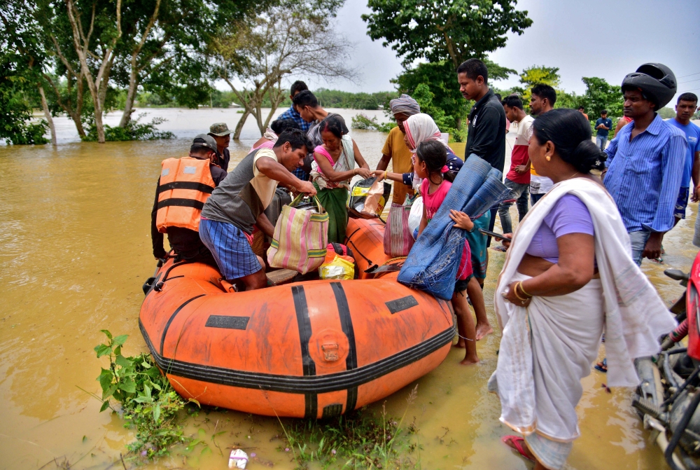 People disembark a boat after they were evacuated from a flooded village in Nagaon district, in the northeastern state of Assam, India, May 18, 2022. REUTERS/Anuwar Hazarika