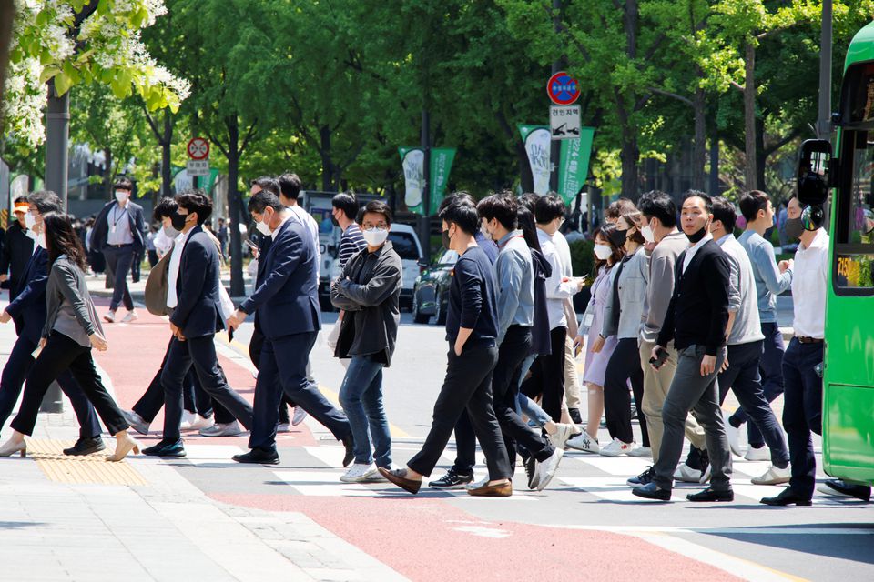 People wear masks to prevent the spread of the coronavirus disease (COVID-19) as they walk on zebra crossing in Seoul, South Korea, May 3, 2022. REUTERS/ Heo Ran

